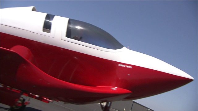 一架红白相间的未来主义飞机展示在跑道上。视频下载