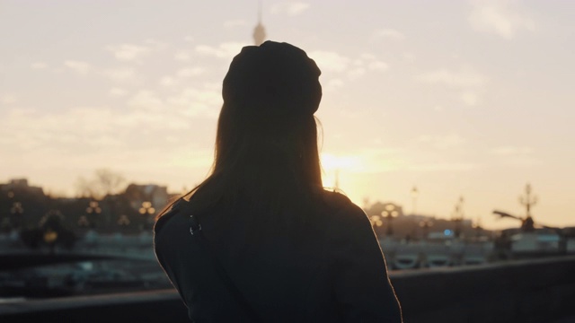 电影的后视图，快乐的女人走在史诗镜头闪耀夕阳塞纳河和埃菲尔铁塔在巴黎的慢镜头。视频素材
