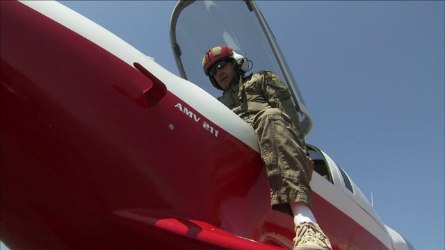 一名飞行员在爬进一架实验飞机的驾驶舱并关闭舱门之前戴上头盔。视频下载