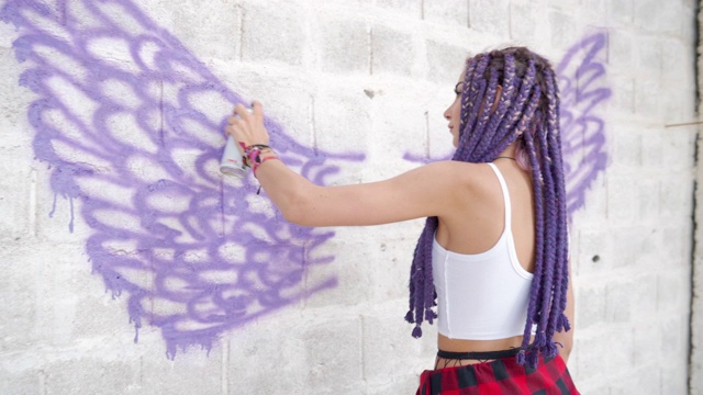 年轻女子在砖墙上涂鸦视频下载