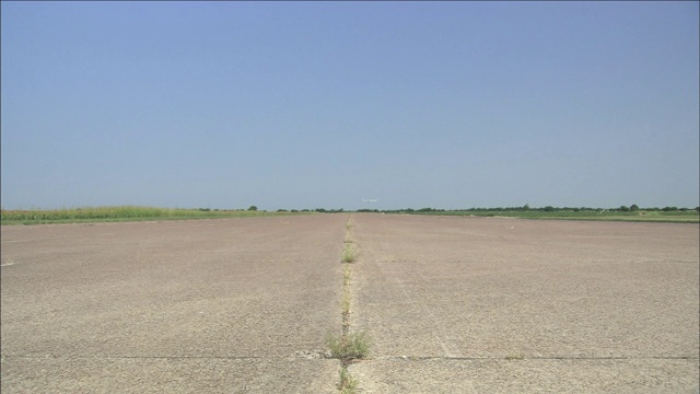 一架小飞机在机场跑道上空低低地飞行。视频下载