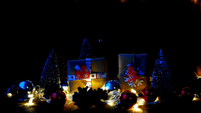 圣诞节和新年的背景与礼物。用牛皮纸包裹的礼物，上面有节日的标志——心形和冷杉树。雪从上面飘落下来。视频素材