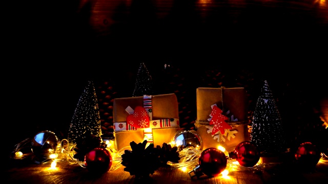 圣诞节和新年的背景与礼物。用牛皮纸包裹的礼物，上面有节日的标志——心形和冷杉树。雪从上面飘落下来。视频素材