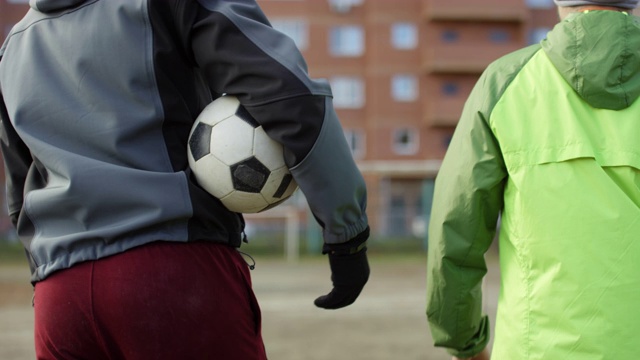 两名足球运动员带着球在户外场上行走视频素材