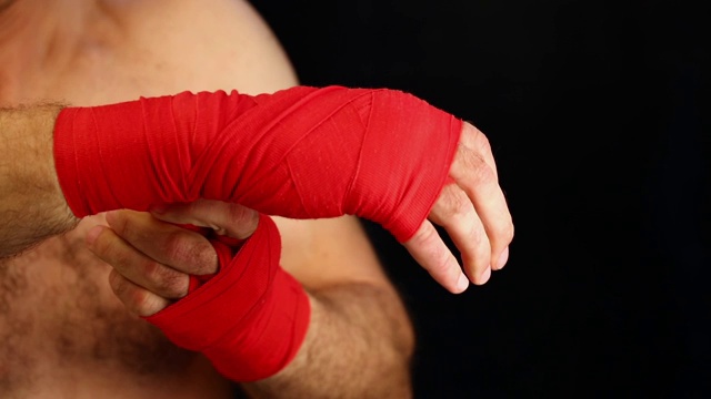近距离男子拳击手用红色的包裹手腕视频下载