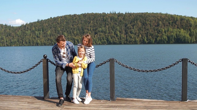 幸福家庭的肖像:母亲，父亲和孩子在户外。美丽的运动家庭在大自然中度过秋天假期视频下载