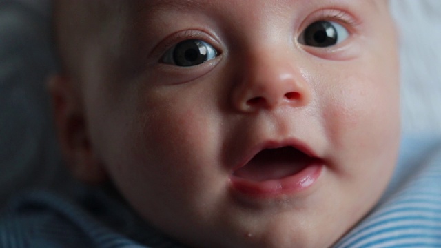 美丽的婴儿新生儿特写脸微笑和感觉幸福视频素材