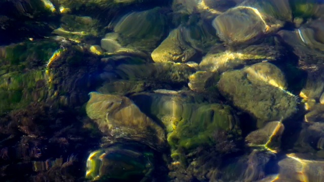 海浪在海滩的石头之间翻腾。视频下载