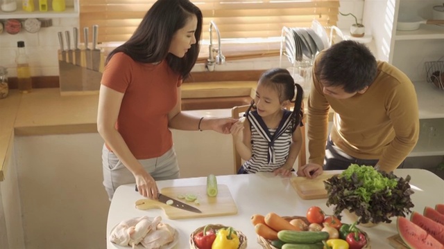 亚洲母亲在厨房教家人如何做饭视频素材