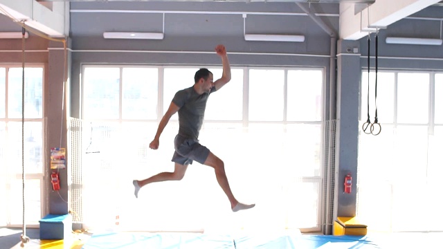 一个雄心勃勃的年轻运动员要在蹦床上表演特技视频下载