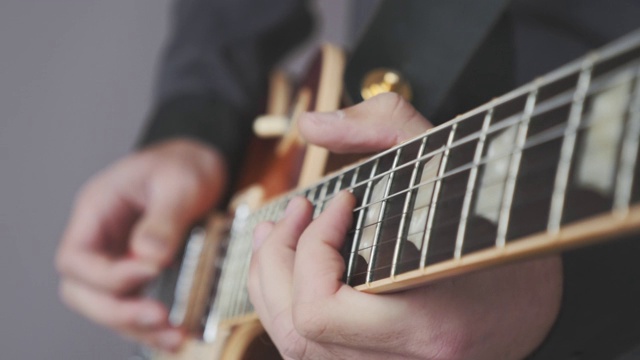 手指在吉他指板上演奏摇滚、爵士和蓝调独奏。近手弹奏电吉他。为摇滚音乐会练习吉他视频素材