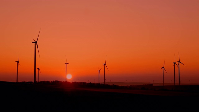 黎明时分风力涡轮机的剪影视频素材