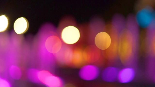 虚景模糊多色装饰舞蹈水射流led灯喷泉秀在晚上和圣诞树的背景。视频下载