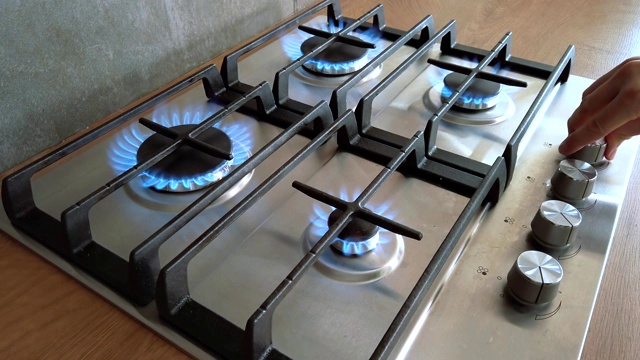 厨房家用燃烧器打开钢制或铁制的灶具，有做饭的火焰。手天然气炎症视频下载