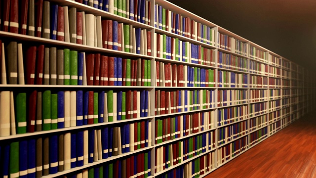 沿着书架移动，每个书架上都有很多不同的书视频素材
