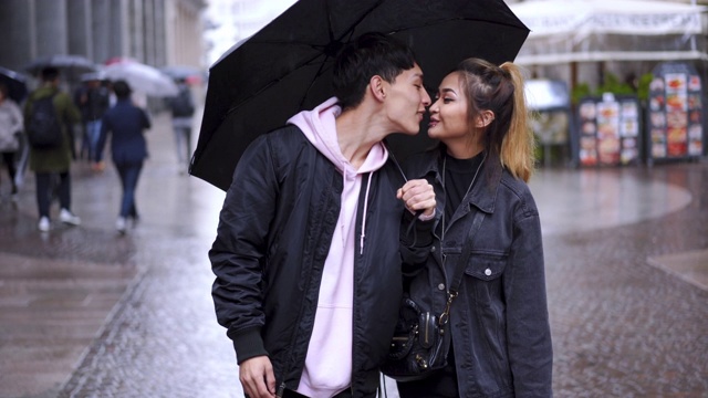 年轻夫妇在雨天浪漫散步视频素材