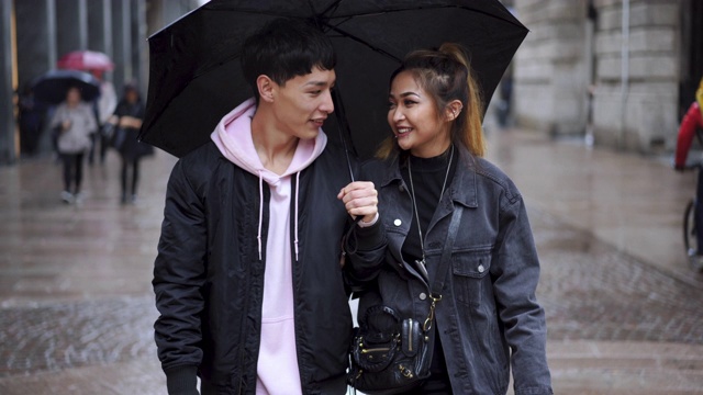 年轻夫妇在雨天浪漫散步视频素材