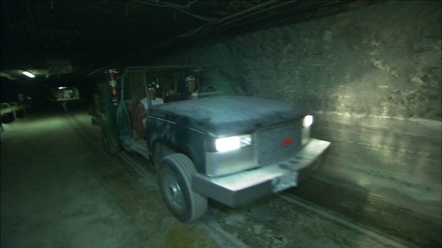 矿工们在隧道里开着一辆多功能车。视频下载