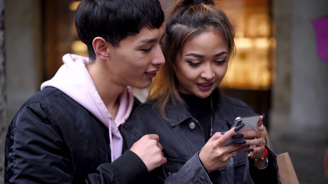 快乐的年轻夫妇玩手机智能手机视频素材