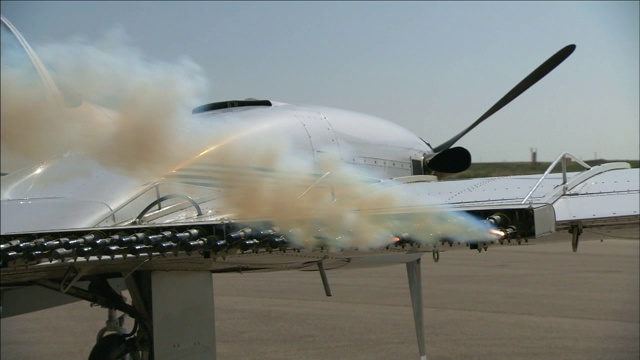 彩色烟雾从一架特技飞机机翼下的信号弹中喷射出来。视频下载
