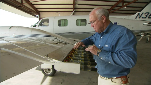 一个机械师在数飞机机翼上的照明弹架上的照明弹。视频素材