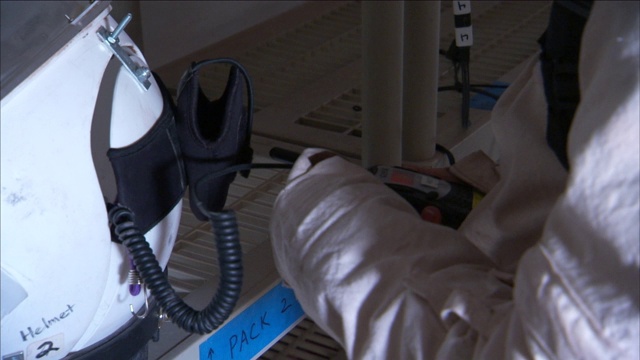 宇航员用监视器检查头盔上的无线电。视频素材