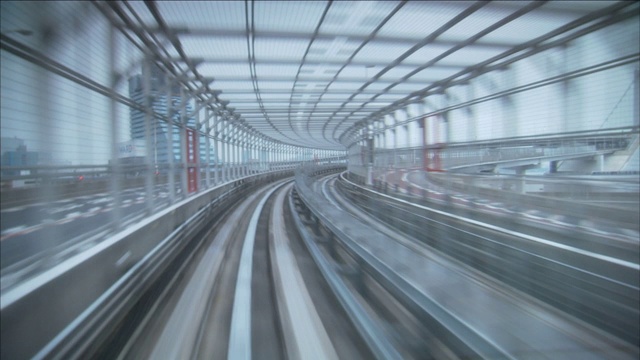 一条铁路蜿蜒穿过摩天大楼附近的隧道。视频下载