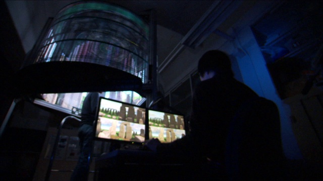 一名技术人员在一台纺纱机附近的电脑上工作。视频素材