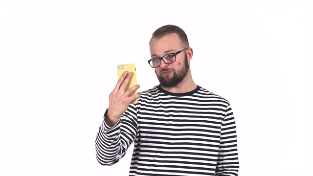 一名穿着条纹毛衣、满脸胡子的白人男子在用智能手机聊天。真正的情感概念视频下载