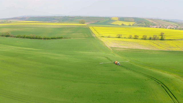 一名空中的农民在一片被风力涡轮机包围的土地上喷洒杀虫剂视频素材