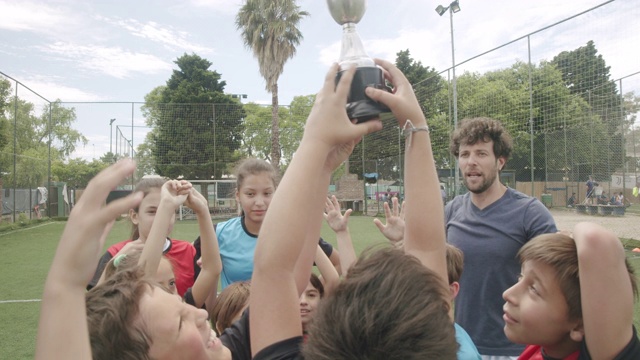 一群孩子在一起庆祝足球比赛的胜利视频素材