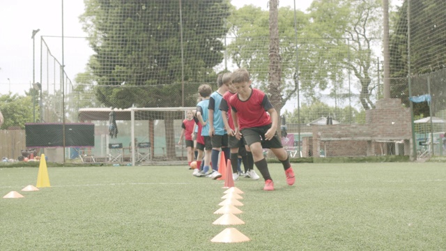 坚定的男孩和女孩在球场上练习足球视频素材