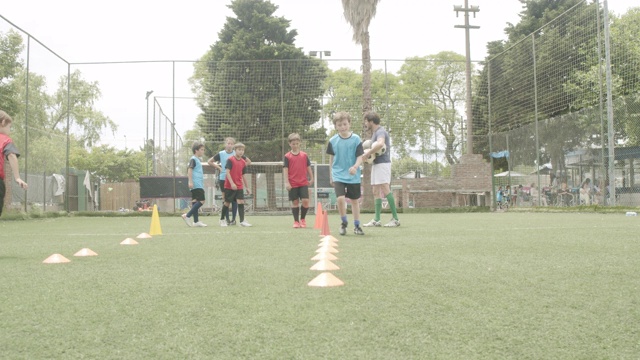 坚定的男孩和女孩在球场上练习足球视频素材