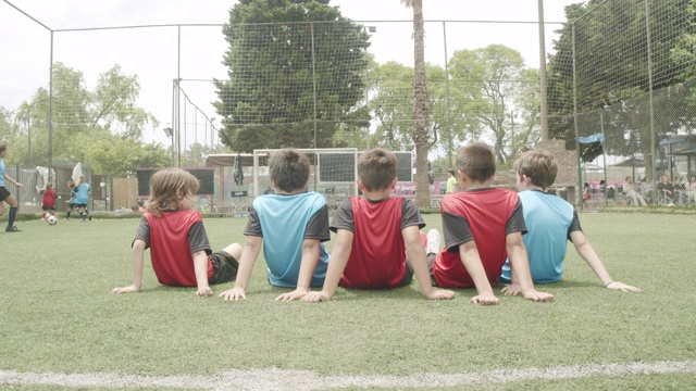 男孩子们一起坐在足球场上视频素材