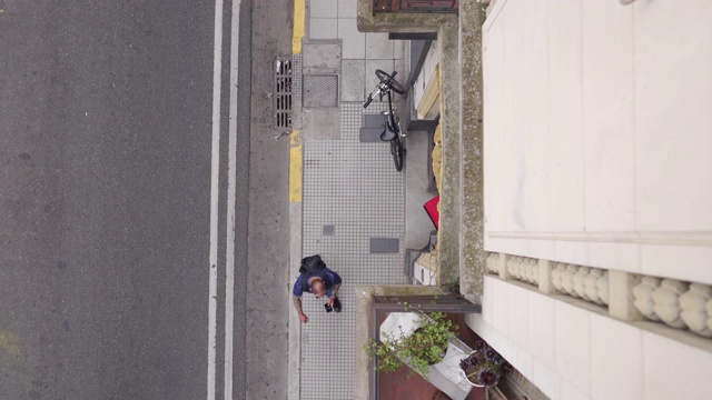 快递员骑着自行车在住宅楼前视频下载