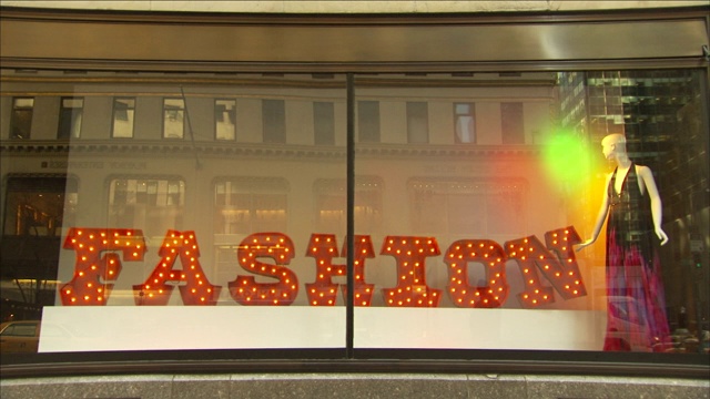 在纽约一家商店的橱窗里，一个发光的“时尚”标志闪闪发光。视频下载