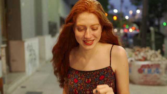 橙色头发的漂亮姑娘走在城里视频下载