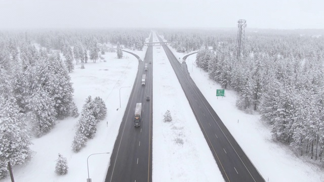无人机:暴风雪期间，卡车和汽车在潮湿的州际公路上行驶。视频素材
