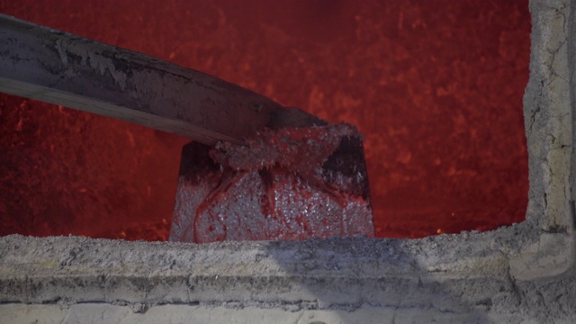 近距离拍摄装载机混合红热铝碗在铝厂。铝铸造炉装金属。炽热的火苗发出红光。在高炉中熔化铝锭视频素材