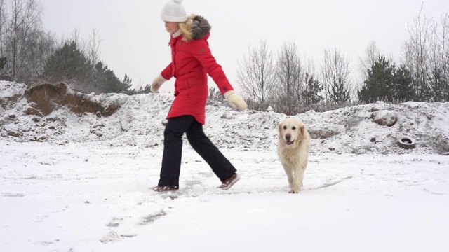 美丽的慢动作视频-女人有乐趣与她的狗在一个溜冰场在冬天视频素材