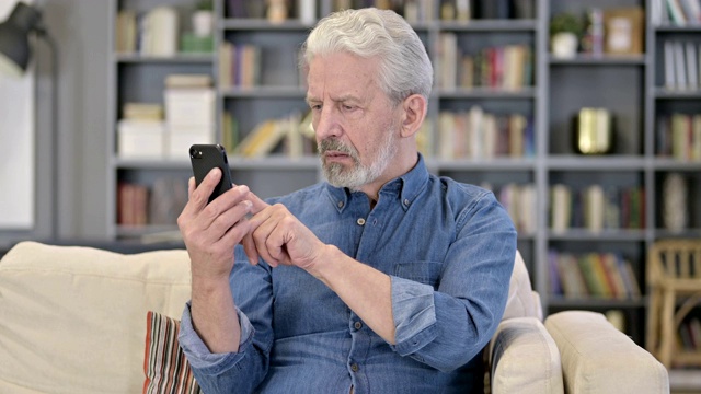 轻松的老男人使用智能手机的肖像视频素材