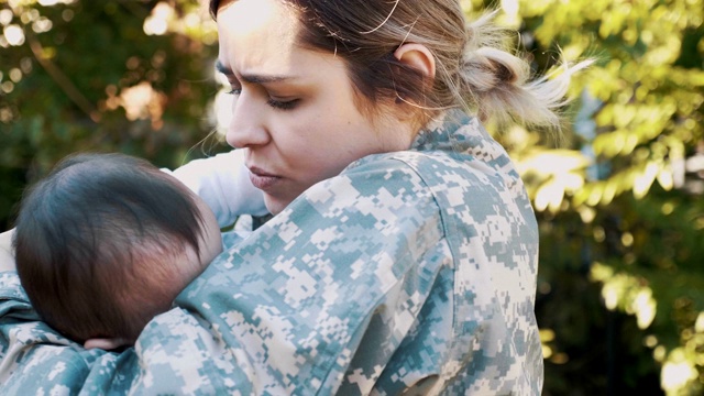 一名女士兵在去执行军事任务前摇晃着她的婴儿视频素材