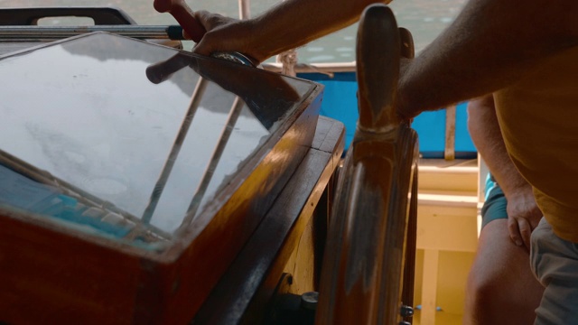 船长转动游艇方向盘的双手。在海上转弯时，男性双手转舵。视频素材