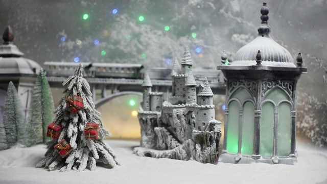 冬季雪景的缩影，桥上有火车，中世纪城堡和灯笼。假日属性。夜景。新年和圣诞节的概念。有选择性的重点视频下载