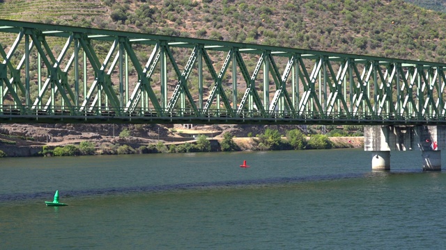 驶向一座铁路桥并在桥下穿过葡萄牙的多罗河视频下载