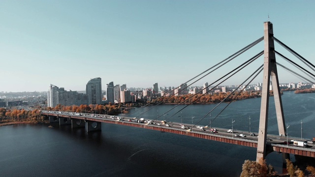 横跨市中心河流的混凝土桥。桥上车辆繁忙，无人机拍摄。连接大都市两岸的大桥。基辅,乌克兰视频素材