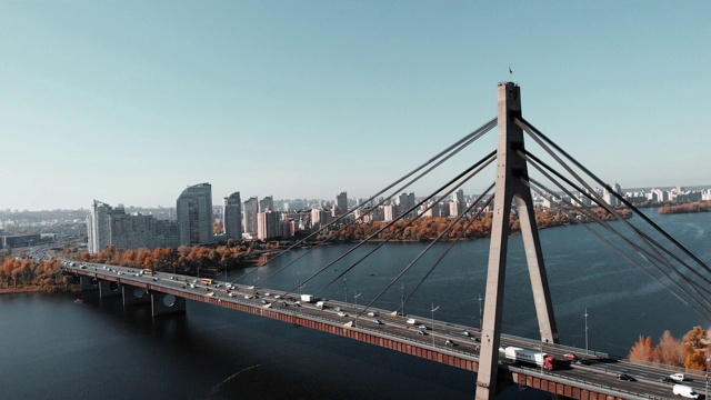 混凝土桥横跨大都市的河流。无人机在大城市大桥附近飞行，背景是高层建筑。市中心河流和桥梁鸟瞰图。基辅,乌克兰视频素材