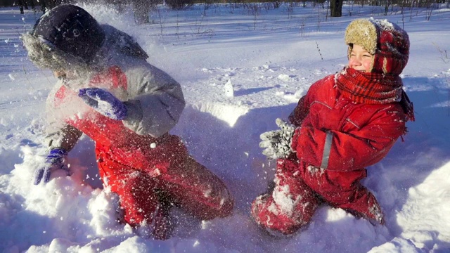 两个孩子在冬季公园一起玩扔雪视频素材