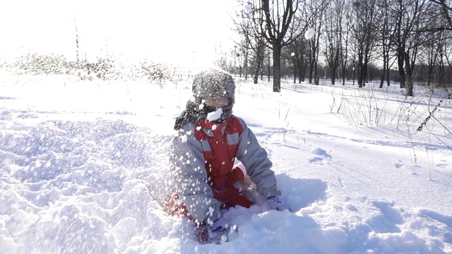 快乐男孩在冬季公园扔雪视频素材