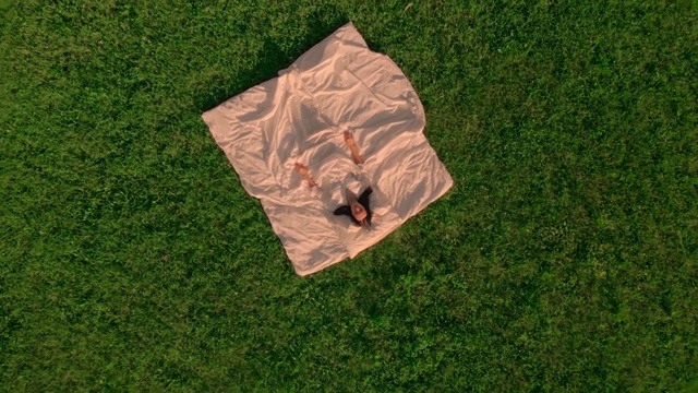 鸟瞰图，在草地上睡觉的女性视频素材